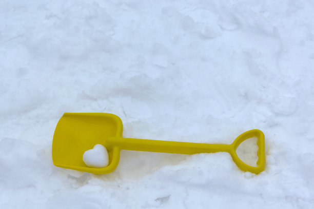 铲躺在洁白的雪地上。图片下载