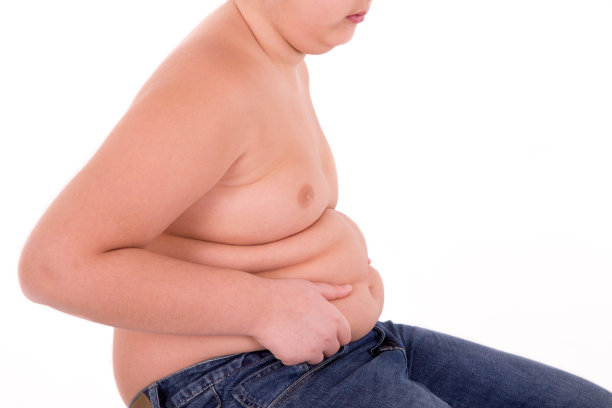 胖男孩用手摸摸他的肚子图片下载