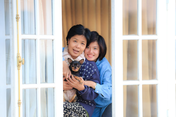 妈妈，女儿和小狗吉娃娃在窗前图片下载