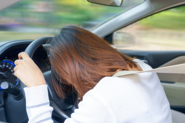 年轻女子在开车时睡觉-危险的概念。图片下载