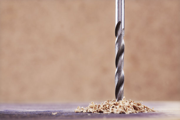 新的金属钻头能在一块木头上钻洞图片下载