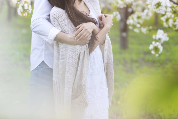 相爱的情侣在春天的公园里亲吻和拥抱图片下载