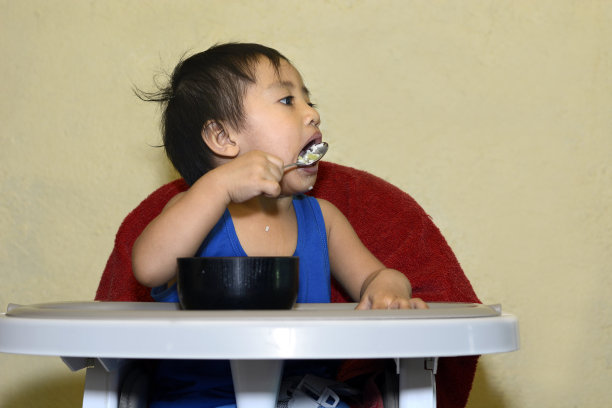 1岁小男孩学着用勺子吃饭图片下载