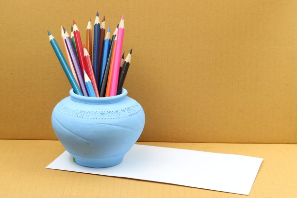 蓝色花瓶里的彩色铅笔。图片下载