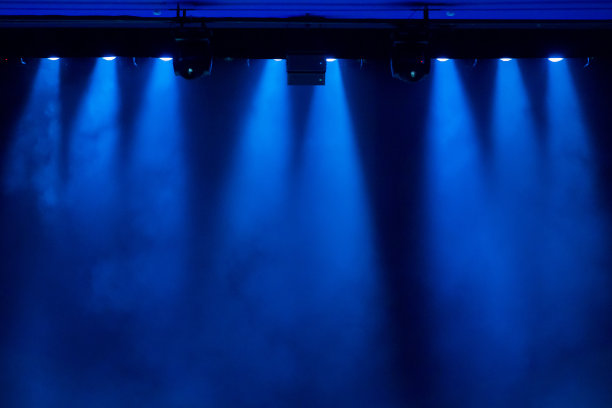 在演出期间，聚光灯发出的蓝光透过剧院里的烟雾。照明设备。图片下载