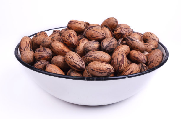 山核桃在一个旧的钢碗里夹着小路图片下载