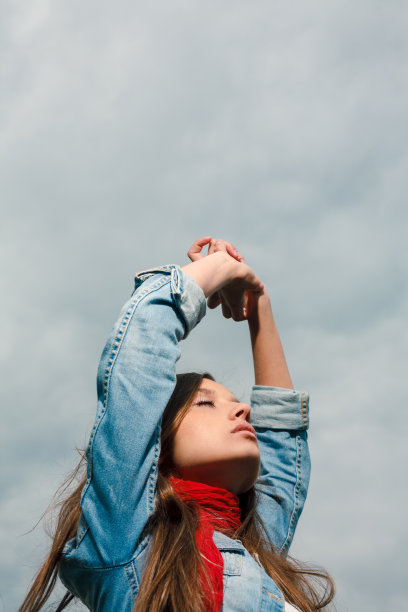 手臂举得高高的漂亮年轻女人图片下载