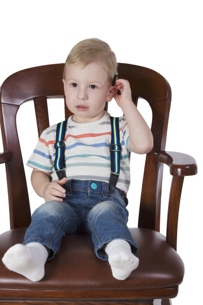 小男孩坐在大椅子上图片下载