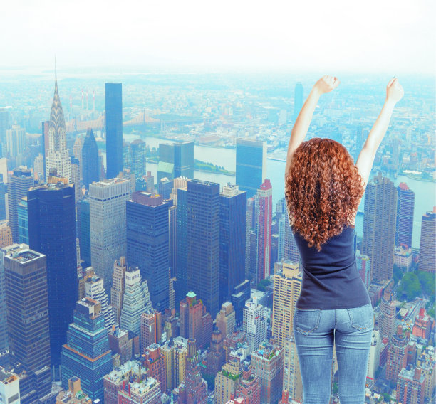 后景，穿着牛仔裤的年轻女子举起手来。后视素材图片