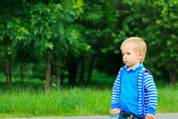 小男孩在公园里骑自行车图片下载
