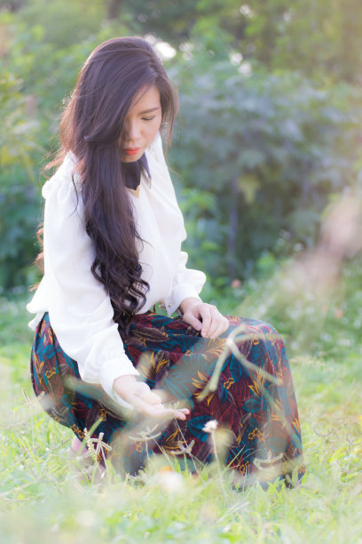 草坪上一位年轻的亚洲女性的简介图片下载