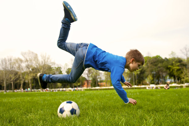 抓拍公园里的一个小孩足球运动员图片下载