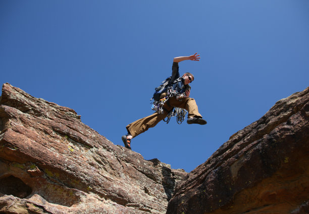攀岩者跃过岩石图片下载