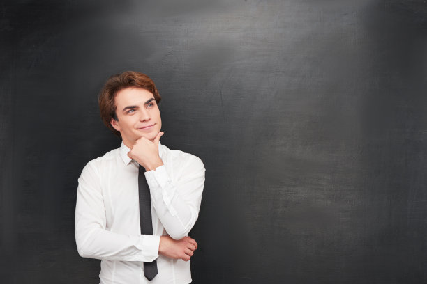 微笑的年轻人在黑板上的背景图片下载