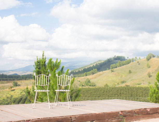 漂亮的白色两把椅子在阳台绿色山景图片下载