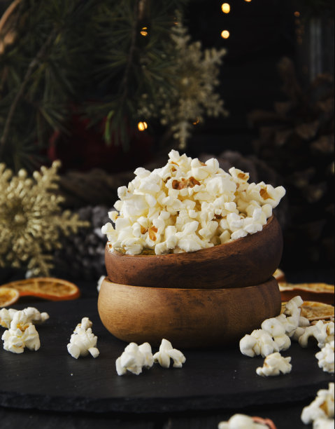 以圣诞节为背景的木盘子里的爆米花图片下载