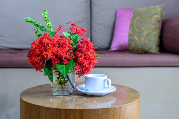 沙发背景上的桌子上放着五颜六色的花瓶、咖啡杯图片下载
