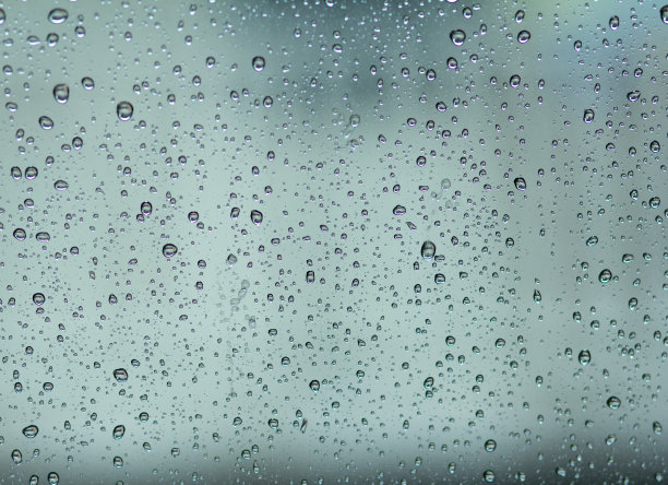 蓝色玻璃背景上的雨滴图片下载