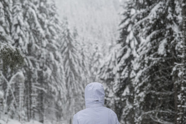 暴风雪中山里戴兜帽的男人图片下载