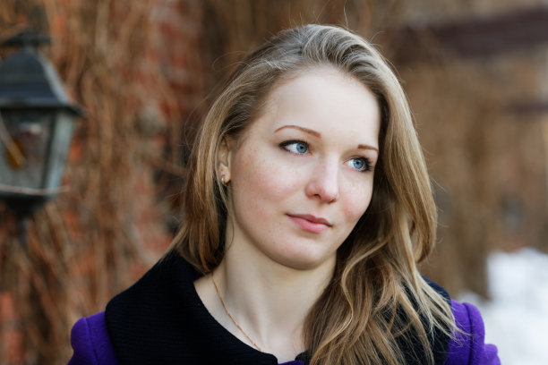 砖墙上一个长着雀斑的女孩的画像图片下载