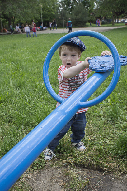 可爱的小男孩在玩跷跷板图片下载