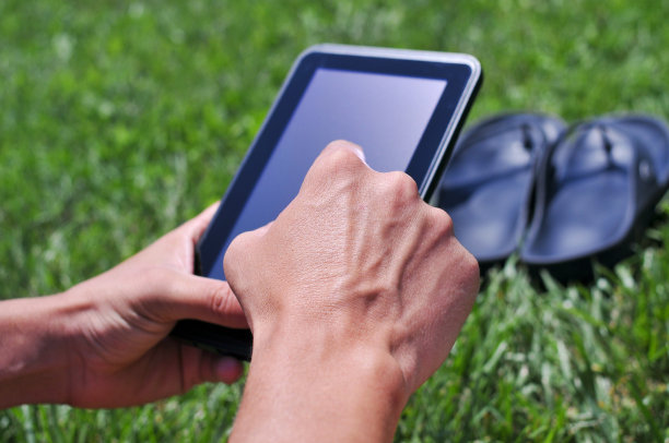 一个年轻人在公园里用平板电脑图片下载