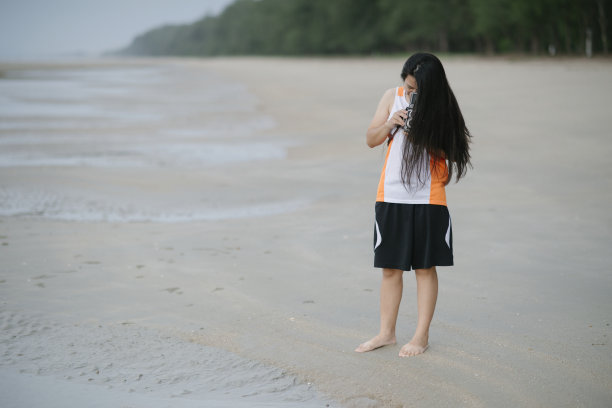 沙滩上拿着老式相机的女人图片下载