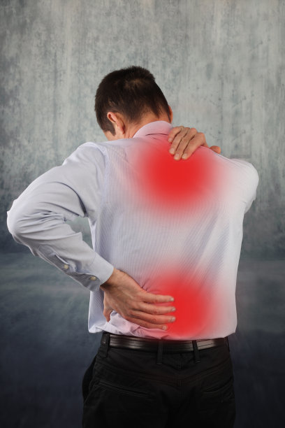 男人揉他的疼痛的背部和颈部近素材图片