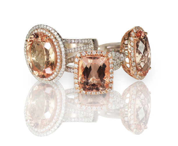 一套三枚钻石和粉色宝石时尚订婚戒指。素材图片