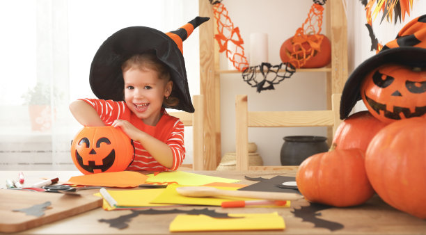 戴着女巫帽子吃糖果的快乐女孩图片下载