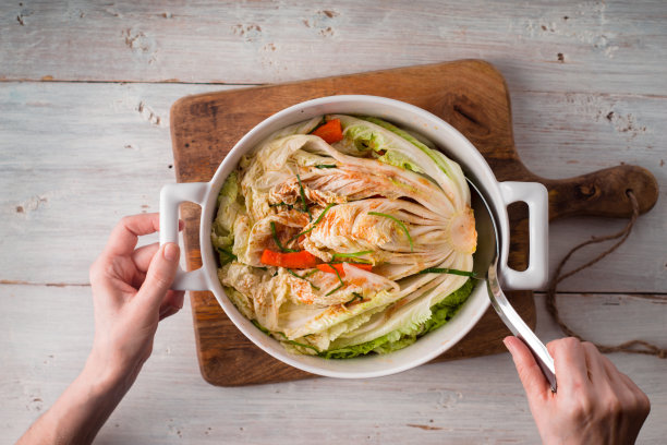 女子从陶瓷碗上取下泡菜图片下载