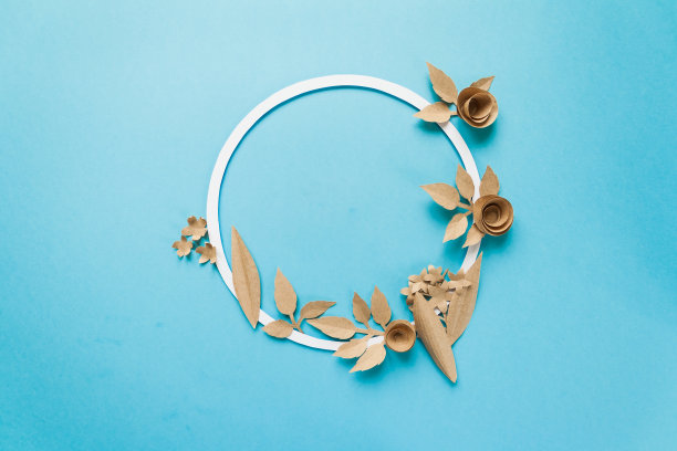 圆形框架与工艺纸花在蓝色的背景。平的。自然概念图片下载