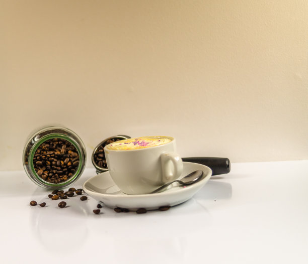 咖啡放在一个白色的杯子里，上面有一罐掉落的咖啡豆和滤嘴，这就是早上的咖啡图片下载