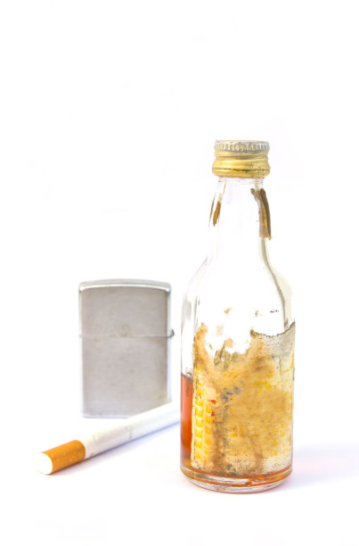 一瓶威士忌和老式的银色金属打火机和香烟图片下载