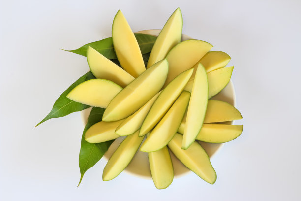 把生芒果和芒果叶削皮放在盘子里图片下载