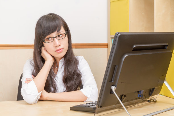 中国女人坐在办公桌前做白日梦图片下载