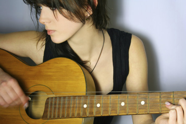 女孩的肖像在黑色背心弹吉他图片下载