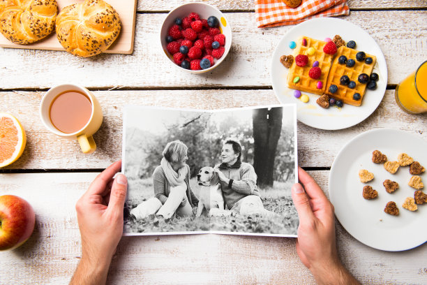手握照片的老夫妇，早餐用餐。工作室的年代图片下载