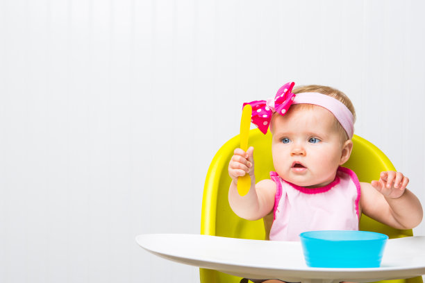 小女孩坐在高脚椅里图片下载