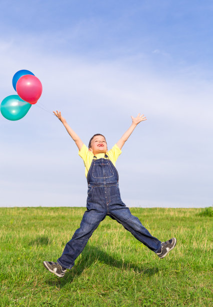 在绿地上跳跃的男孩图片下载