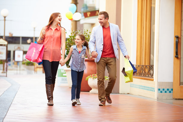 一家人拿着购物袋穿过购物中心图片下载