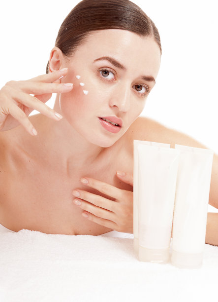 在脸上涂抹保湿霜的女人。图片下载
