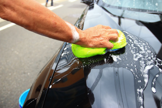 用手拿海绵在汽车上清洗图片下载