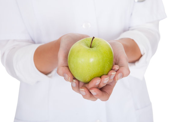 手持青苹果的年轻女医生图片下载