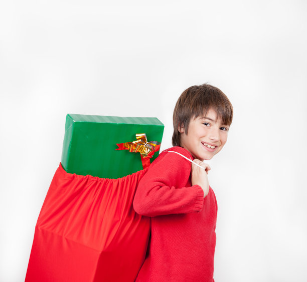 快乐的孩子背着一个装满圣诞礼物的袋子图片下载