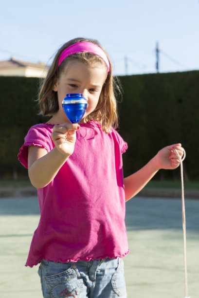 小女孩在玩旋转陀螺图片下载