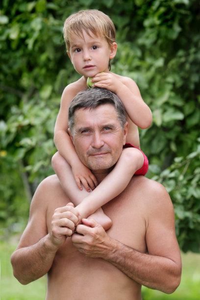 可爱的男孩坐在男人的肩膀上图片下载