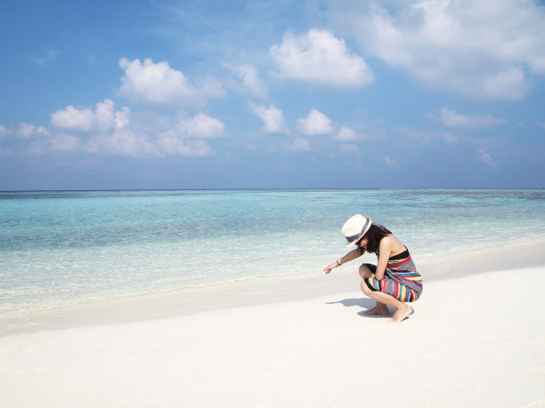 一位年轻的女士在马尔代夫岛的海滩上图片下载