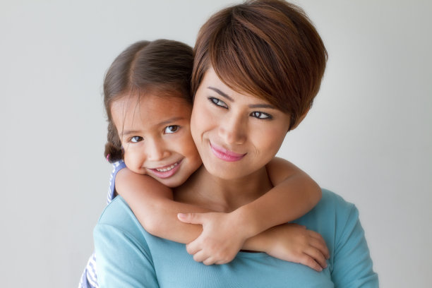 幸福的家庭与微笑，积极的女儿拥抱她的母亲图片下载