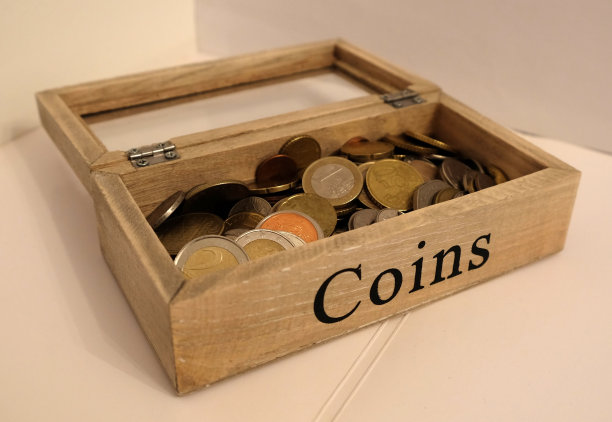 装满硬币的木制钱箱。图片下载